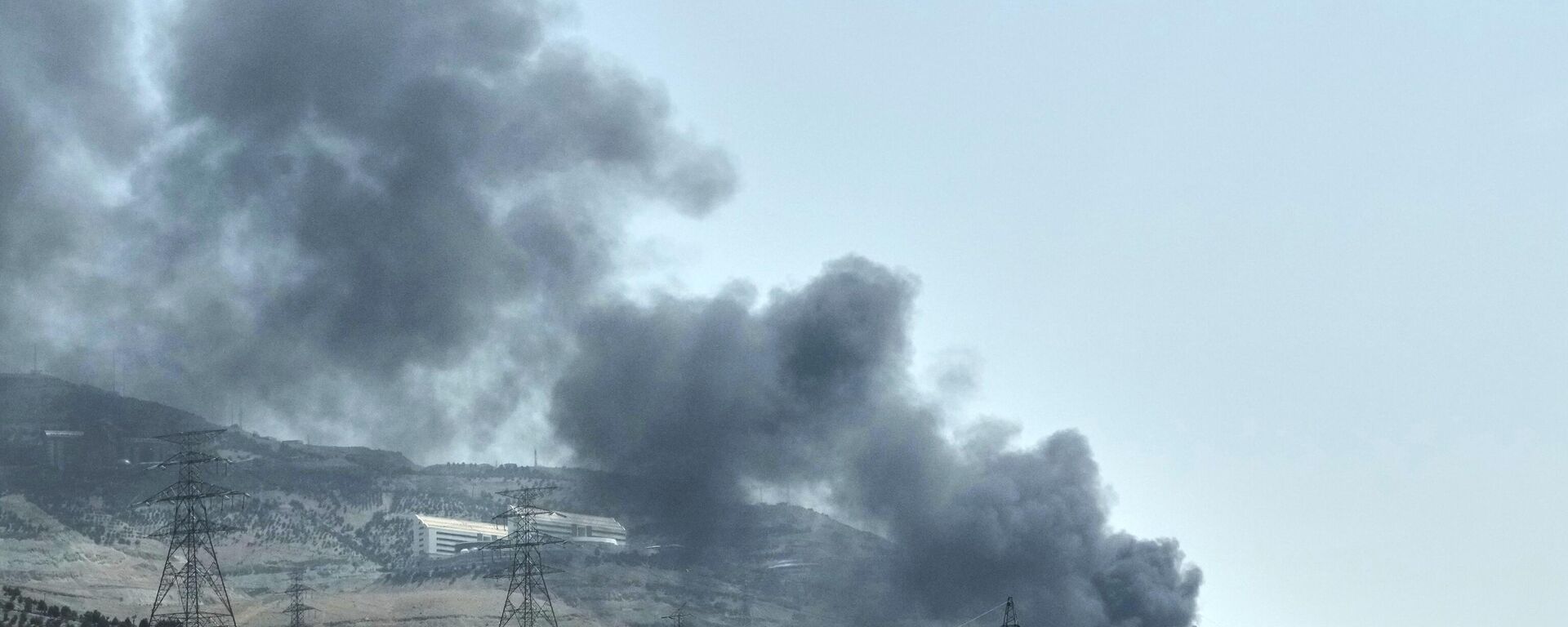 يتصاعد الدخان من منشأة لتخزين النفط بعد تعرضها لضربة إسرائيلية يوم السبت، في طهران - سبوتنيك عربي, 1920, 22.06.2025
