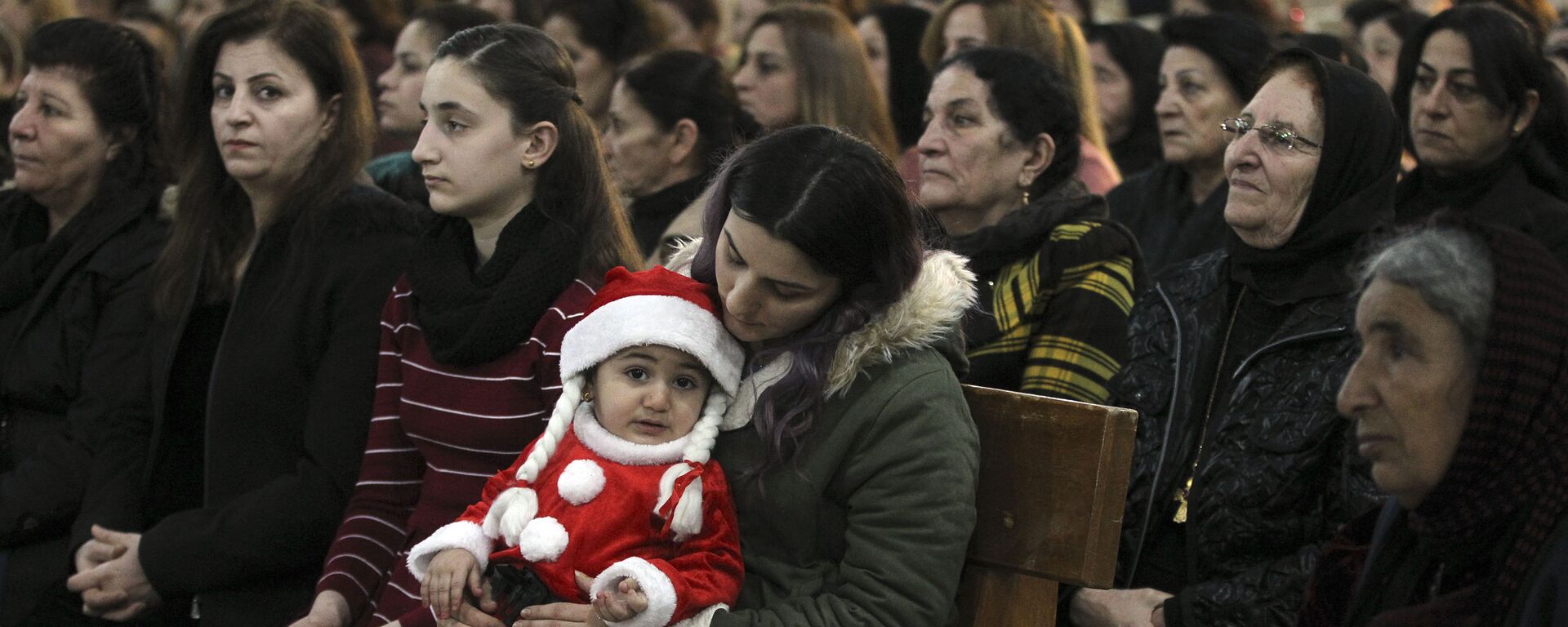 مسيحيون عراقيون خلال قداس عيد الميلاد في مدينة قراقوش، العراق - سبوتنيك عربي, 1920, 20.11.2022