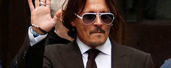 الممثل الأمريكي، جوني ديب، يلوح أثناء مغادرته المحكمة العليا في لندن، بريطانيا، 10 يوليو/ تموز 2020 - سبوتنيك عربي