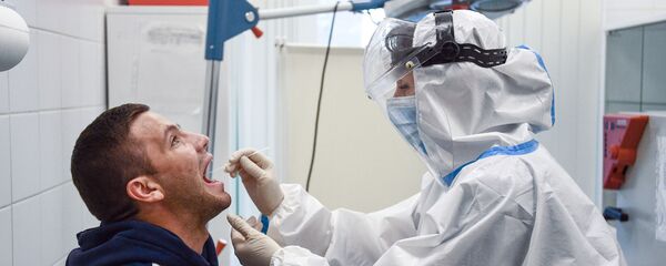 عمل اختبار المرض الفيروسي كوفيد-19، الذي يسببه فيروس كورونا، للركاب في مطار شيريميتيفو في موسكو، روسيا 20 يوليو 2020 - سبوتنيك عربي