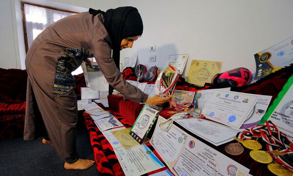 مدربة الفنون القتالية وبطلة الكيك بوكسينج اليمنية سهام عامر تعرض شهاداتها و ميدالياتها في منزلها في صنعاء، اليمن 3 سبتمبر 2020 - سبوتنيك عربي