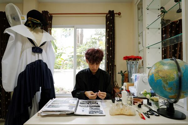 المصمم التايلندي تين تونسوبون يجلس في استوديو عمله أمام تصاميمه في بانكوك، تايلاند 15 سبتمبر 2020 - سبوتنيك عربي