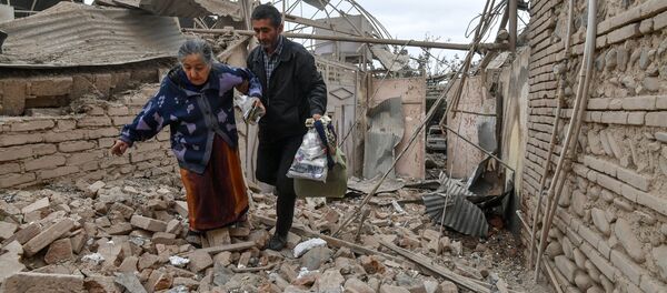 سكان منزل دمره قصف على مدينة كنجه في أذربيجان، في ظل التصعيد العسكري بين أرمينيا وأذربيجان، 4 أكتوبر 2020 - سبوتنيك عربي