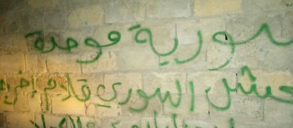 شعارات تطالب بطرد الجيش الأمريكي عن بلدة يسيطرون عليها شرق سوريا - سبوتنيك عربي