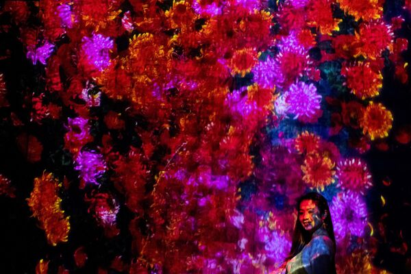 فتاة تلتقط صورة على خلفية صورة رقمية في معرضغابة من المصابيح المنيرة، في متحف موري للفنون الرقمية في مدينة طوكيو، اليابان 14 أكتوبر 2020 - سبوتنيك عربي