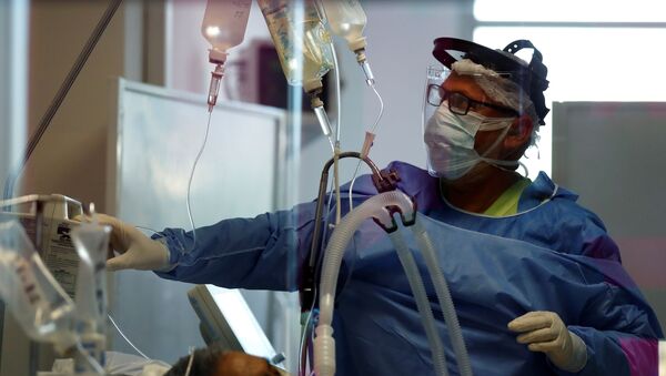 ممرض تفحص مريضا يعاني من مرض فيروس كورونا في وحدة العناية المركزة بأحد المستشفيات في ضواحي بوينس آيرس بالأرجنتين - سبوتنيك عربي
