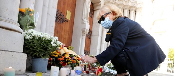 مواطنون يحضرون الشموع و أكاليل الزهور أمام كاتدرائية نوتردام في مدينة نيس، حيث وقعت حادثة طعن يوم 29 أكتوبر، فرنسا 30 أكتوبر 2020 - سبوتنيك عربي