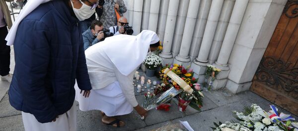 مواطنون يحضرون الشموع و أكاليل الزهور أمام كاتدرائية نوتردام في مدينة نيس، حيث وقعت حادثة طعن يوم 29 أكتوبر، فرنسا 30 أكتوبر 2020 - سبوتنيك عربي