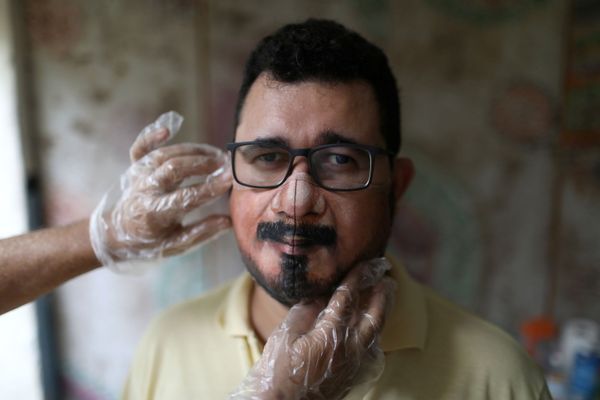 الفنان التشكيلي البرازيلي، خورخي سيلفا روريز، يقوم بتجربة الكمامة المصممة على الزيون، ويعمل في منزله في ريو دي جانيرو، وسط تفشي مرض فيروس كورونا (كوفيد-19) في البرازيل، 10 نوفمبر 2020. - سبوتنيك عربي
