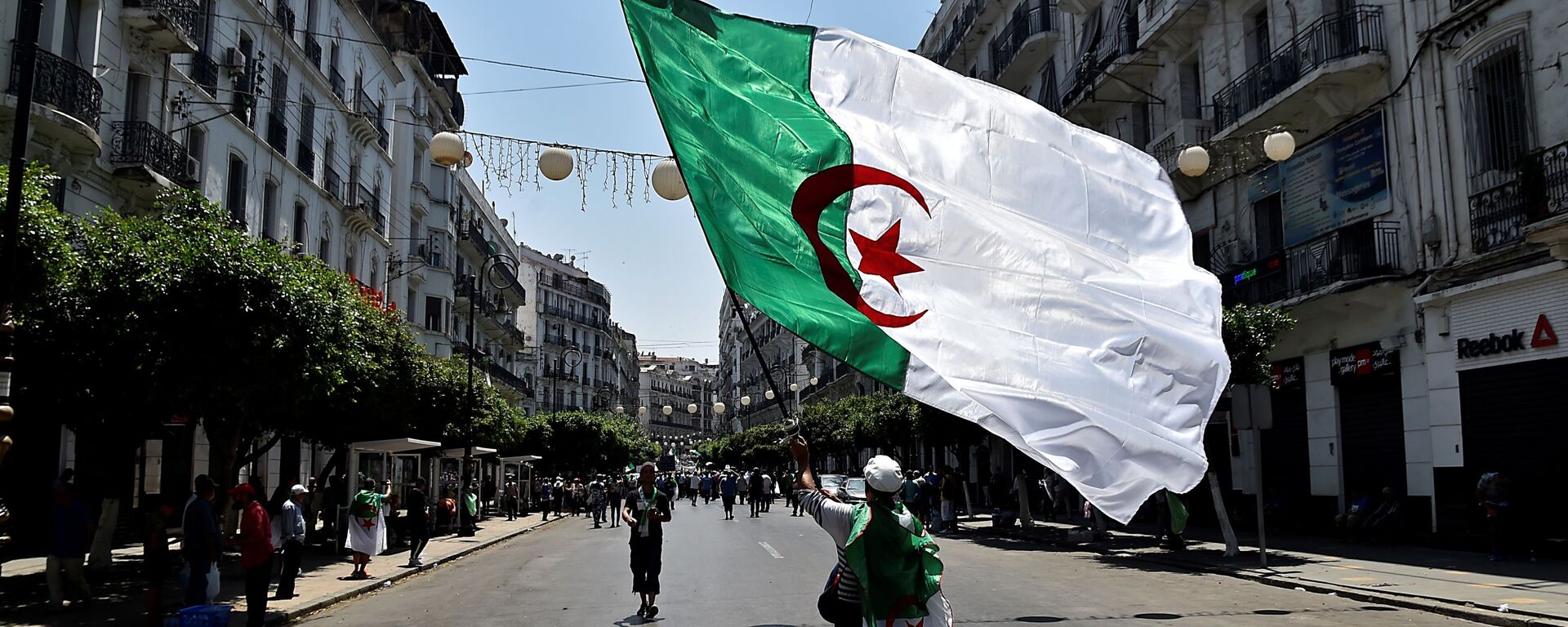 صورة لمتظاهر جزائري في الجزائر العاصمة يوم 26 يوليو 2019 ، في آخر أسابيع من المسيرات ضد الطبقة الحاكمة وسط أزمة سياسية مستمرة في البلاد - سبوتنيك عربي, 1920, 29.11.2021