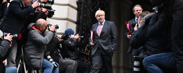 رئيس الوزراء البريطاني بوريس جونسون يعود إلى 10 داونينغ ستريت في لندن، 8 ديسمبر 2020، بعد ترأسه الاجتماع الأسبوعي لمجلس الوزراء الذي عقد في مكتب الخارجية والكومنولث والتنمية القريب. أشادت بريطانيا يوم الثلاثاء الماضي بنقطة تحول في الحرب ضد الجائحة، حيث شرعت بأكبر برنامج لتطعيم المواطنين في تاريخ البلاد بلقاح جديد ضد كوفيد -19. - سبوتنيك عربي