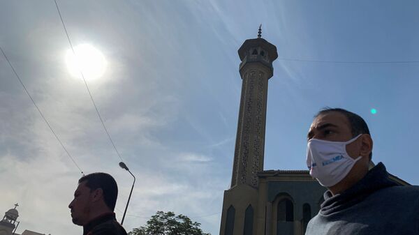 رجل يرتدي كمامة واقية من فيروس كورونا وفي الخلفية مأذنة مسجد في مصر نوفمبر تشرين الثاني - سبوتنيك عربي