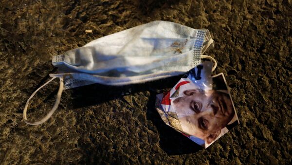 صورة لنتياهو ملقاة على الأرض بجوار كمامة خلال احتجاج على فساد رئيس الوزراء الإسرائيلي وتعامله مع أزمة فيروس كورونا - سبوتنيك عربي