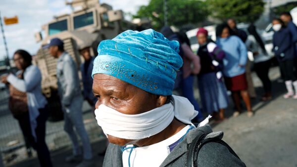 امرأة مسنة تغطي وجهها بقناع مؤقت خلال جائحة فيروس كورونا في جنوب أفريقيا - سبوتنيك عربي