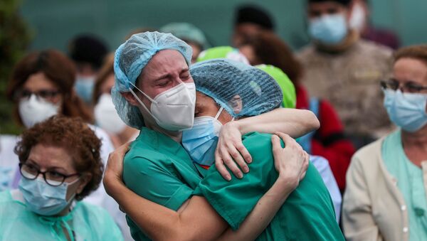 عاملون طبيون يبكون خلال تكريم زميلهم المتوفى خلال جائحة كورونا في ليغانيس بإسبانيا - سبوتنيك عربي