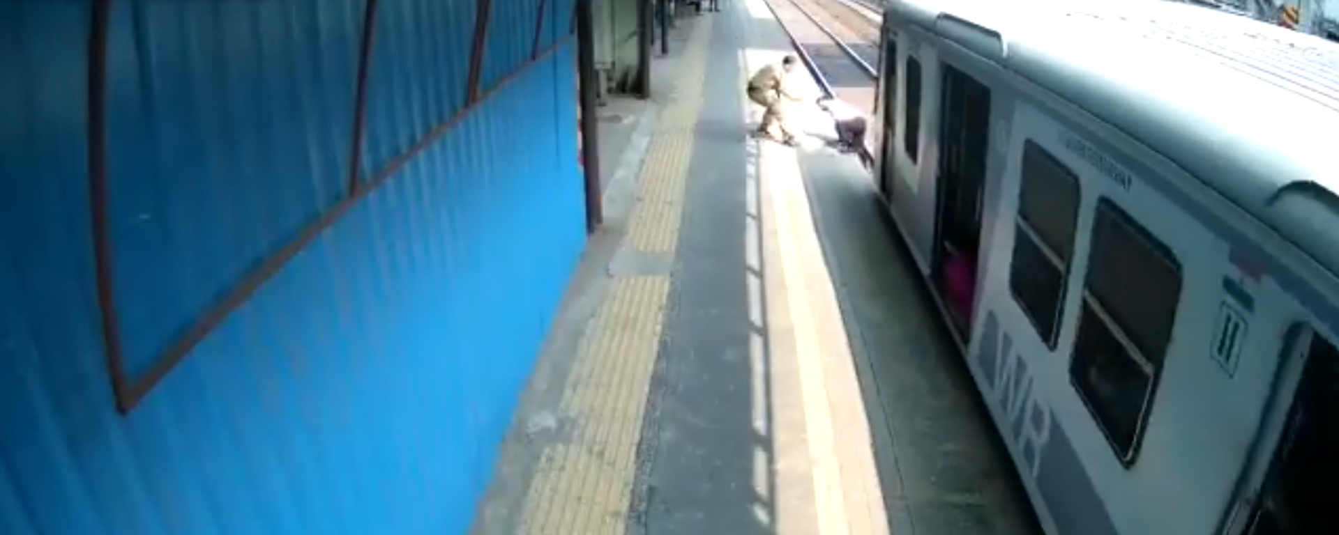 شرطي في مومباي يساعد رجلا علق على السكك الحديدية  - سبوتنيك عربي, 1920, 02.01.2021