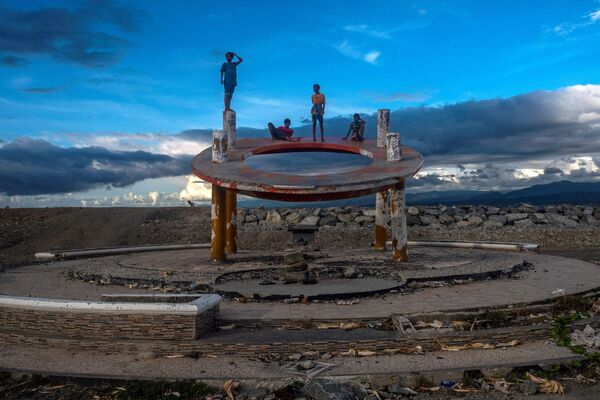 الأولاد يلعبون في موقع ركام النصب التذكاري السابق في بالو، مقاطعة سولاويزي الوسطى، إندونيسيا ، 13 يناير 2021 - سبوتنيك عربي