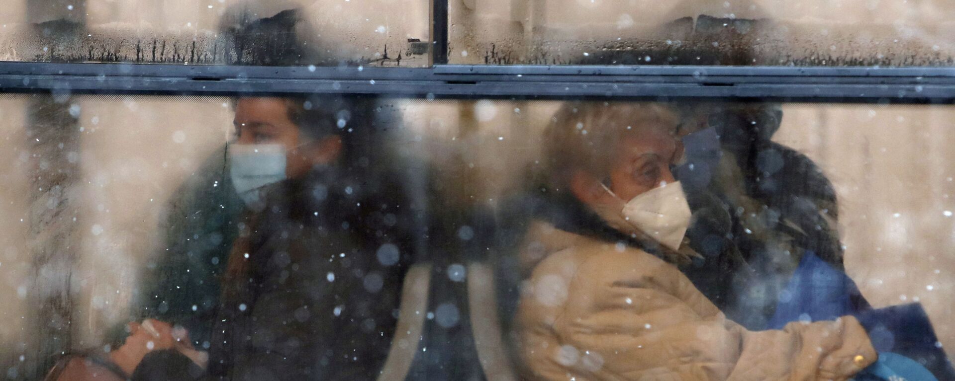 أشخاص يرتدون كمامات للوقاية من فيروس كورونا يجلسون على متن حافلة في بلغراد، صربيا،11 يناير 2021.  - سبوتنيك عربي, 1920, 07.08.2022
