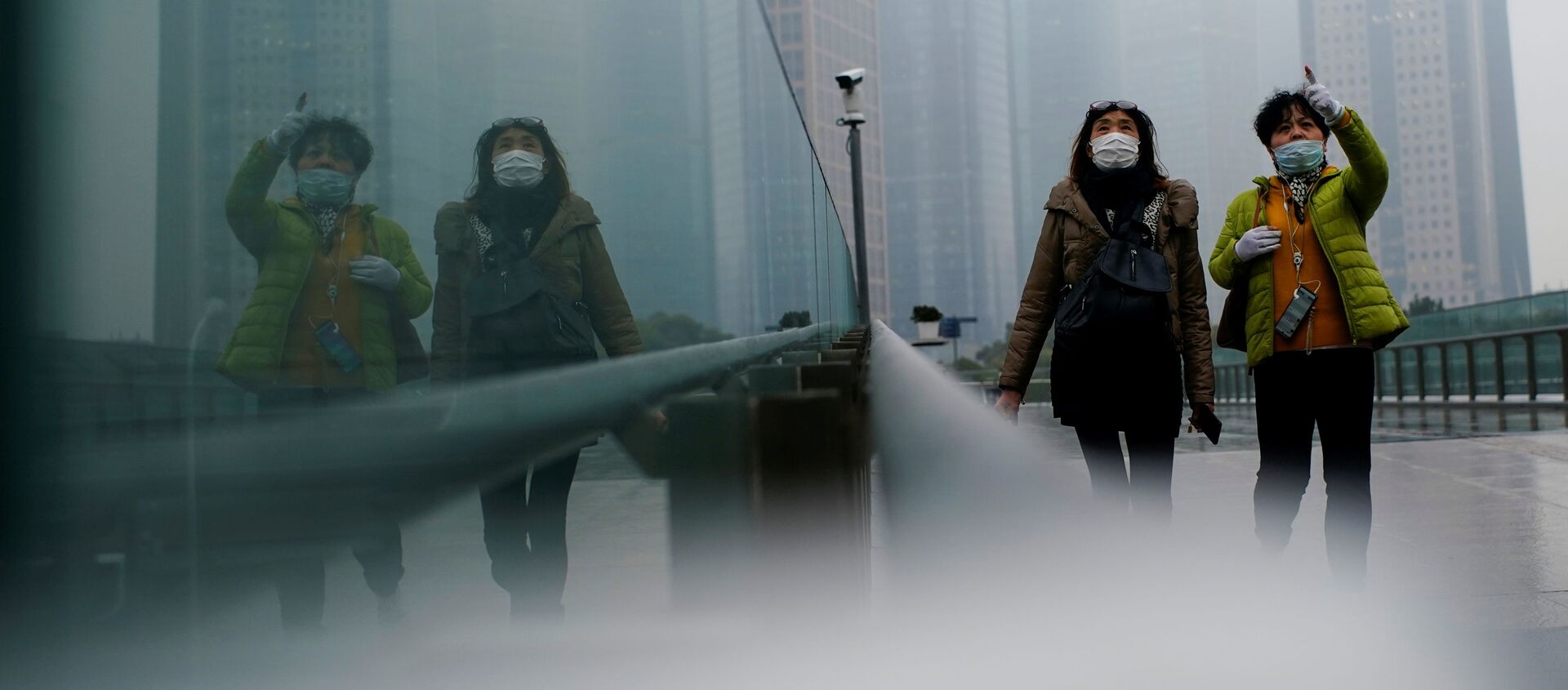 أشخاص يرتدون كمامات يسيرون في أحد الشوارع وسط تفشي مرض فيروس كورونا (كوفيد-19) في شنغهاي الصين، 26 يناير 2021 - سبوتنيك عربي, 1920, 21.06.2021