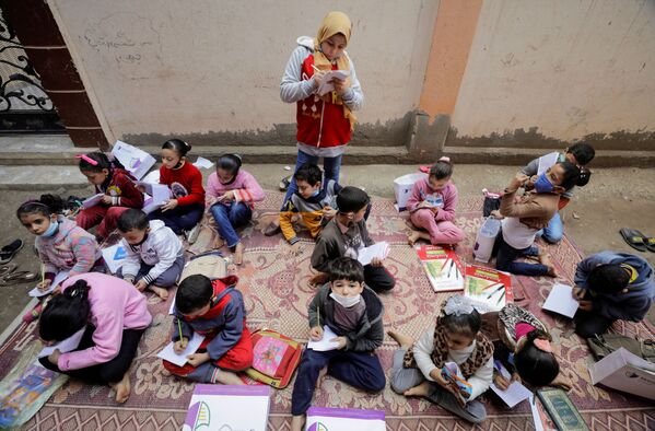 ريم الخولي، 12 عامًا، تعلم الأطفال في حيها حيث لاتزال المدارس مغلقة وسط جائحة فيروس كورونا (كوفيد-19)، في قرية إتميدة بمحافظة الدقهلية، مصر، 7 فبراير 2021 - سبوتنيك عربي