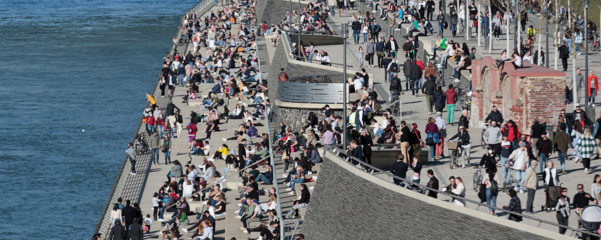 يقضي الناس وقتًا تحت أشعة الشمس على ضفاف نهر الراين وسط جائحة كورونا (كوفيد-19) في مدينة كولونيا في ألمانيا، 21 فبراير 2021. - سبوتنيك عربي, 1920, 11.06.2021