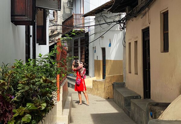 امرأة تلتقط صوراً في أحد أحياء مدينة زنجبار، تنزانيا 18 فبراير 2021 - سبوتنيك عربي