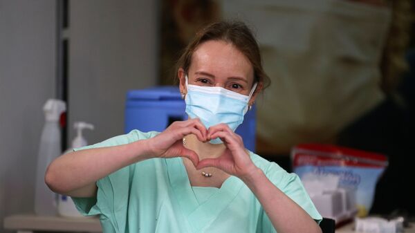 سيلفيا أليخاندرا جيلفيز، طبيبة الطوارئ في عيادة كولومبيا، تصنع إشارة القلب بيديها قبل تلقيها حقنة بجرعة من لقاح فايزر ضد كوفيد-19 في عيادة كولومبيا في بوغوتا، كولومبيا، 18 فبراير 2021 - سبوتنيك عربي