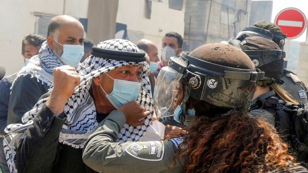 متظاهر فلسطيني يشتبك مع شرطية حدود إسرائيلية خلال مسيرة يوم الأرض، في سبسطية بالقرب من نابلس، في الضفة الغربية،  في 30 مارس 2021 - سبوتنيك عربي