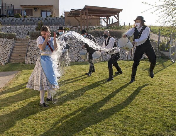 حبس التقليد المجري القديم، في يوم الاثنين بعد عيد الفصح يرتدي الأهالي الأزياء الشعبية، ويقوم الشباب، أعضاء جمعية ماركال للرقص والفنون الشعبية، بصب الماء على الفتيات الشابات، في مينفوكساناك، المجر، 5 أبريل 2021. - سبوتنيك عربي