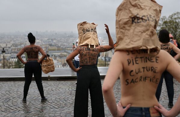 متظاهرون يعبرون عن احتجاجهم ضد إغلاق متاجر التجزئة غير الضرورية، أمام كاتدرائية ساكري كور في باريس، في 5 أبريل 2021 - سبوتنيك عربي