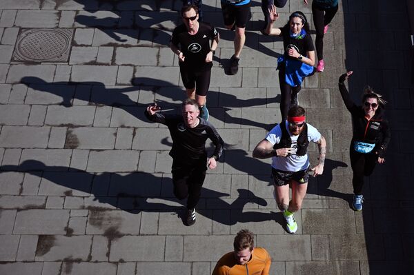 أشخاص يافعون خلال رياضة الركض على ضفة نهر موسكو، روسيا 11 أبريل 2021 - سبوتنيك عربي