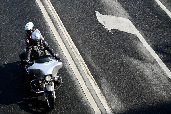 أشخصان يركبان دراجة نارية على ضفة نهر موسكو في موسكو، روسيا 11 أبريل 2021 - سبوتنيك عربي