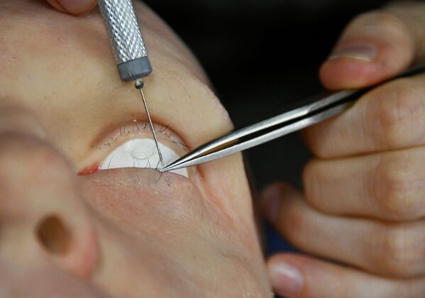 موظف يركب رموش العين لرجل آلي طورته شركة بروموبوت (Promobot) لتصنيع الروبوتات، في فرع الشركة لنمذجة الروبوتات البشرية في أقصى شرق مدينة فلاديفوستوك، روسيا، 15 مارس 2021 - سبوتنيك عربي