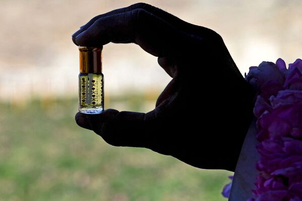 عامل يعرض زجاجة من زيت ورد الطائف المقطر من مزرعة بن سلمان في مدينة الطائف السعودية في 13 مارس 2021 - سبوتنيك عربي