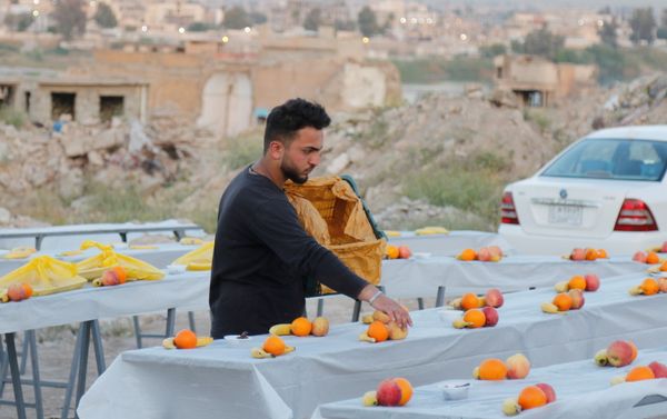 شاب يعد الطعام لوجبات الإفطار ويضع الفواكه على طاولة إفطار رمضان في الموصل، العراق، 15 أبريل 2021 - سبوتنيك عربي