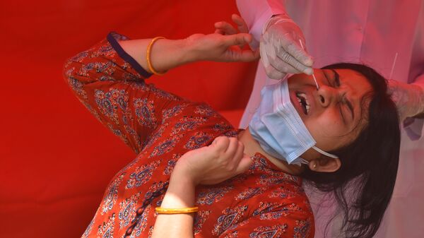 كارثة إنسانية كبرى - تسجيل أرقام قياسية لحالات الإصابة بمرض كوفيد-19، امرأة شابة تلجأ لاختبار كورونا في نيودلهي، الهند 28 أبريل 2021 - سبوتنيك عربي