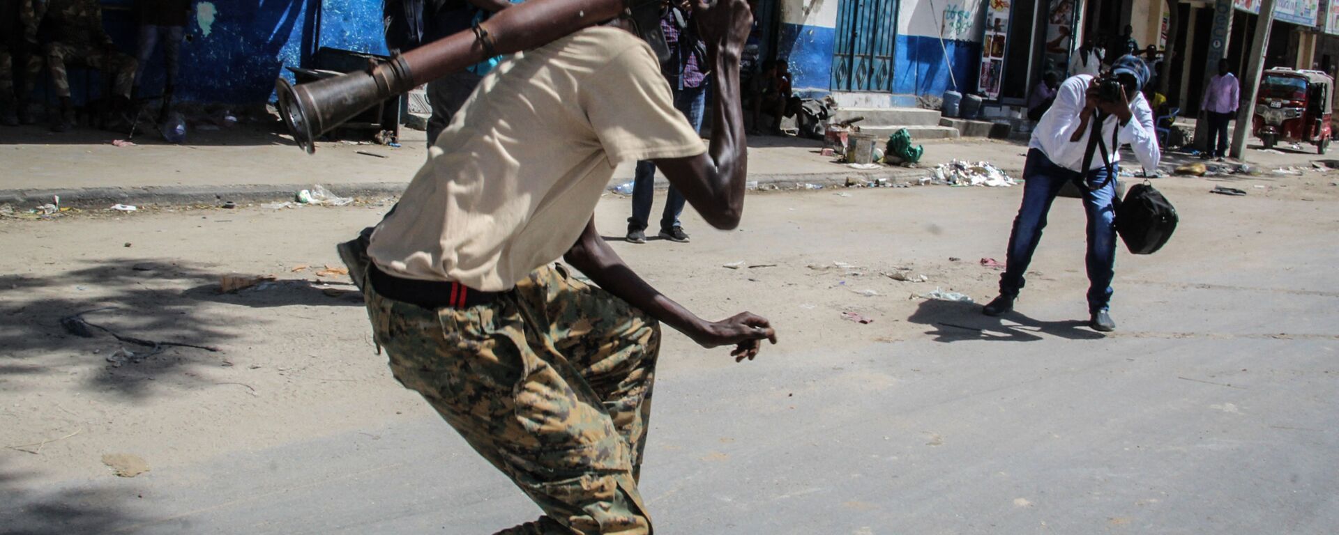 شخص يلتقط صورة لعضو في القوة العسكرية الصومالية يدعم المناوئين للحكومة أثناء وقوفه في أحد شوارع مقديشو، الصومال، 25 أبريل 2021 - سبوتنيك عربي, 1920, 25.09.2022