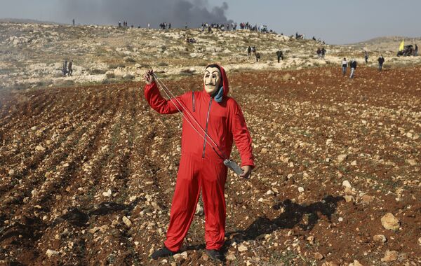 متظاهر فلسطيني يرتدي قناع سلفادور دالي، المستوحاة من المسلسل الإسباني الشهير لا كاسا دي بابيل ( بيت من ورق وبيت المال)، خلال احتجاجات ضد استمرار مماراسات الاستيطان في قرية دير جرير، شمال رام الله، الضفة الغربية، فلسطين 1 يناير 2021 متظاهر فلسطيني يرتدي قناع سلفادور دالي، المستوحاة من المسلسل الإسباني الشهير لا كاسا دي بابيل ( بيت من ورق وبيت المال)، خلال احتجاجات ضد استمرار مماراسات الاستيطان في قرية دير جرير، شمال رام الله، الضفة الغربية، فلسطين 1 يناير 2021 - سبوتنيك عربي