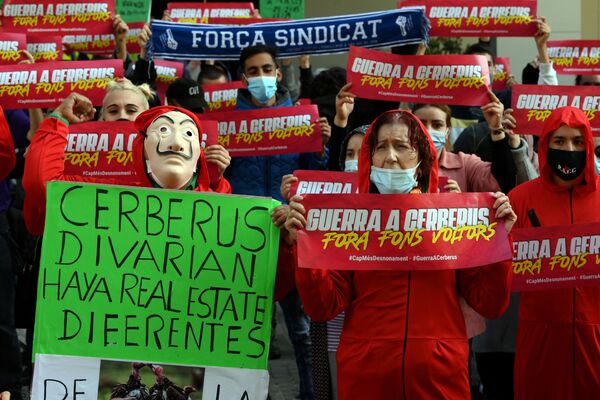 أعضاء من حركة مناهضة للإخلاء والمؤيدون للحق في الحصول على سكن جديد، يرتدون أزياء حمراء وأقنعة على شكل وجه سلفادور دالي، المستوحاة من المسلسل الإسباني الشهير لا كاسا دي بابيل ( بيت من ورق وبيت المال)، ويحملون لافتات كتب عليها الحرب على سيربيروس كجزء من إجراء احتجاجي ضد شركة الأسهم الخاصة الأمريكية سيربيروس كابيتال مانجمنت، في برشلونة 30 نوفمبر 2020 أعضاء من حركة مناهضة للإخلاء والمؤيدون للحق في الحصول على سكن جديد، يرتدون أزياء حمراء وأقنعة على شكل وجه سلفادور دالي، المستوحاة من المسلسل الإسباني الشهير لا كاسا دي بابيل ( بيت من ورق وبيت المال)، ويحملون لافتات كتب عليها الحرب على سيربيروس كجزء من إجراء احتجاجي ضد شركة الأسهم الخاصة الأمريكية سيربيروس كابيتال مانجمنت، في برشلونة 30 نوفمبر 2020 - سبوتنيك عربي