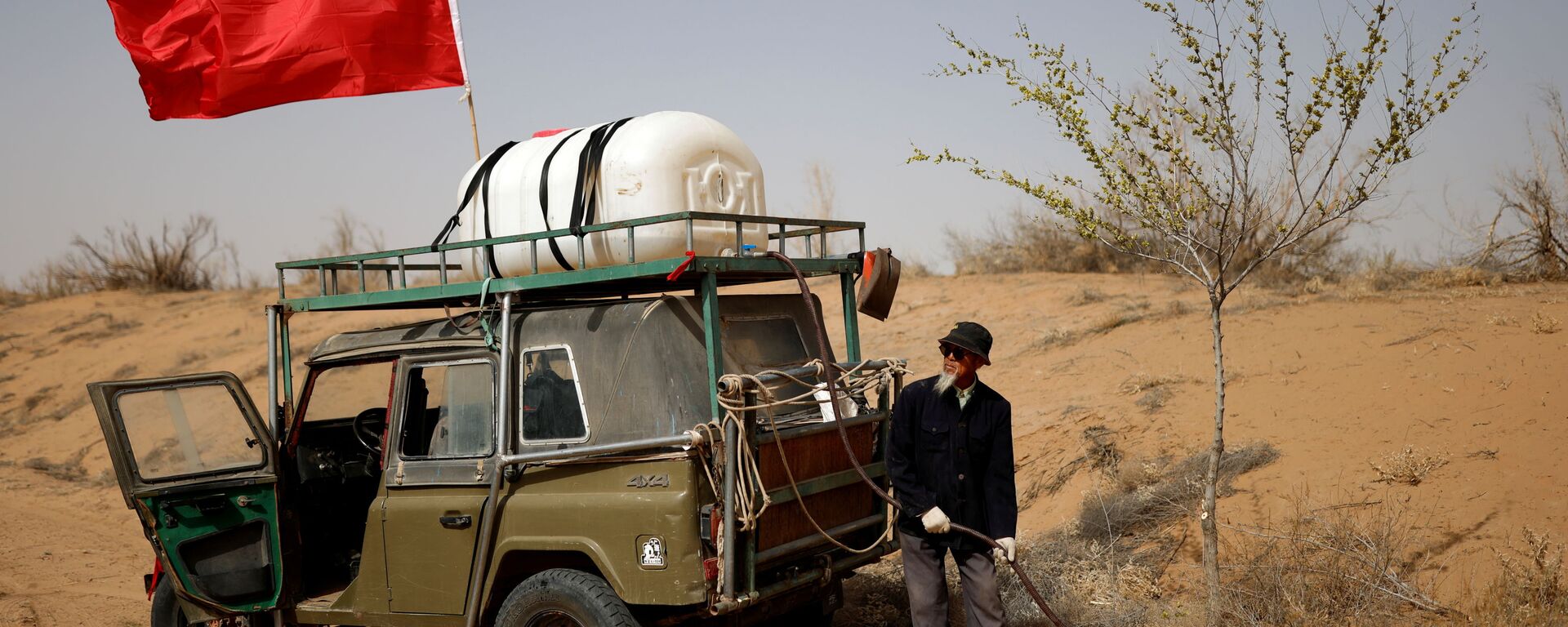 وانغ تيانتشانغ، 78 عامًا، يسقي شجرة مزروعة على حافة صحراء غوبي في ضواحي وووي، مقاطعة غانسو، الصين، 15 أبريل 2021 - سبوتنيك عربي, 1920, 03.06.2021