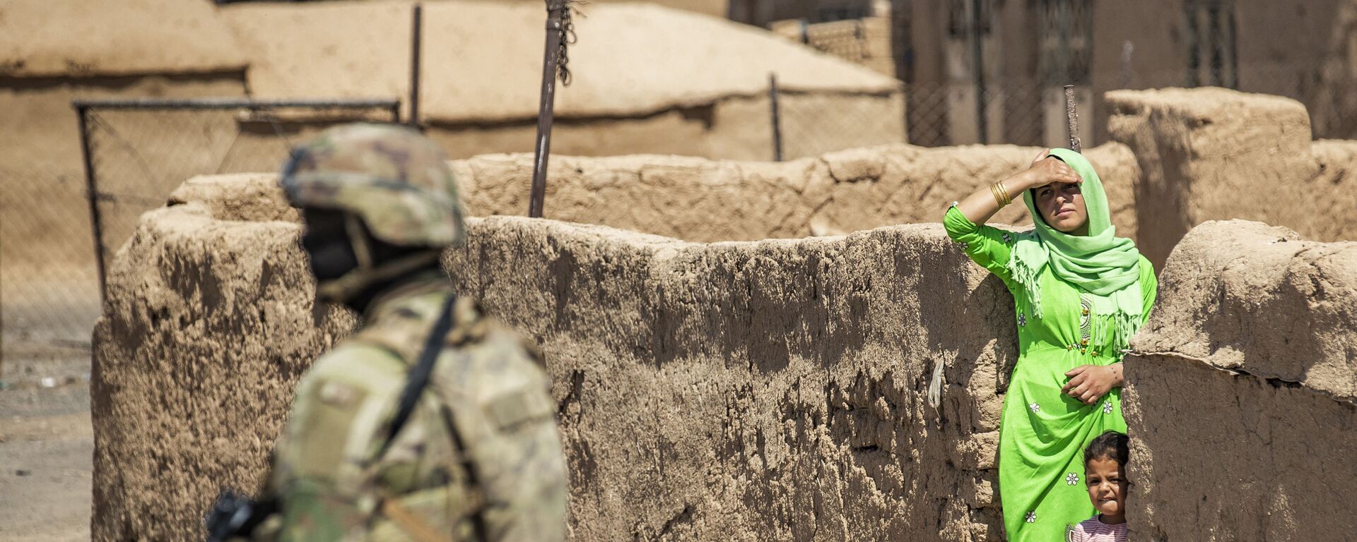   امرأة وطفل ينظران إلى جندي أمريكي يقف خلال دورية عسكرية أمريكية في الرميلان، في محافظة الحسكة شمال شرق سوريا، 22 يونيو 2021 - سبوتنيك عربي, 1920, 25.07.2023