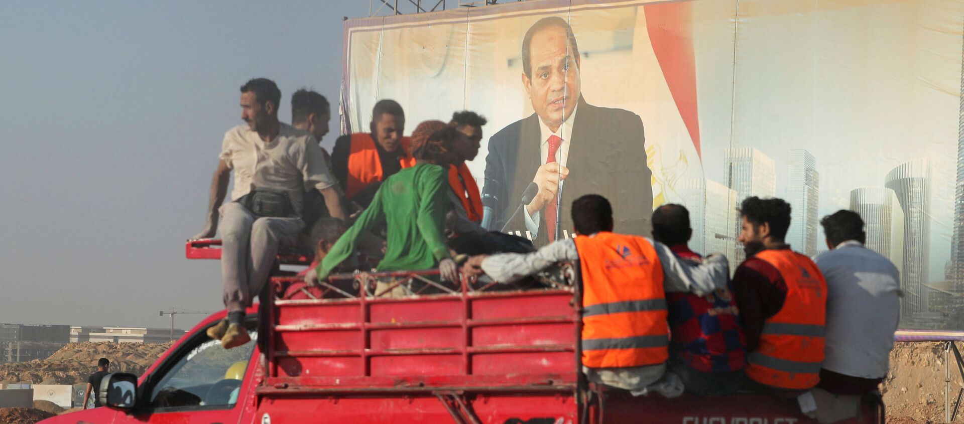 عمال البناء يمرون بجوار لافتة للرئيس المصري عبدالفتاح السيسي في العاصمة الإدارية الجديدة، مصر 5 يوليو 2021 - سبوتنيك عربي, 1920, 03.08.2021