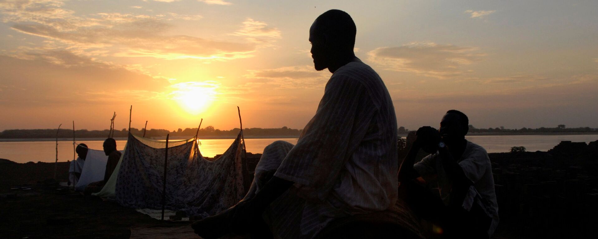 شخص يقف على خلفية غروب الشمس والنيل الأزرق في الخرطوم، السودان 8  يوليو 2007  - سبوتنيك عربي, 1920, 28.08.2021