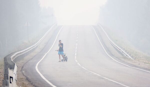 دخان يتصاعد في موقع حرائق الغابات بالقرب من قرية ماغاراس في ياقوتيا، روسيا 15 يوليو 2021 - سبوتنيك عربي