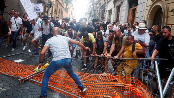 متظاهرون يزيلون حاجزًا للشرطة خلال مظاهرة ضد خطة الممر الأخضر في روما، إيطاليا 27 يوليو 2021 - سبوتنيك عربي