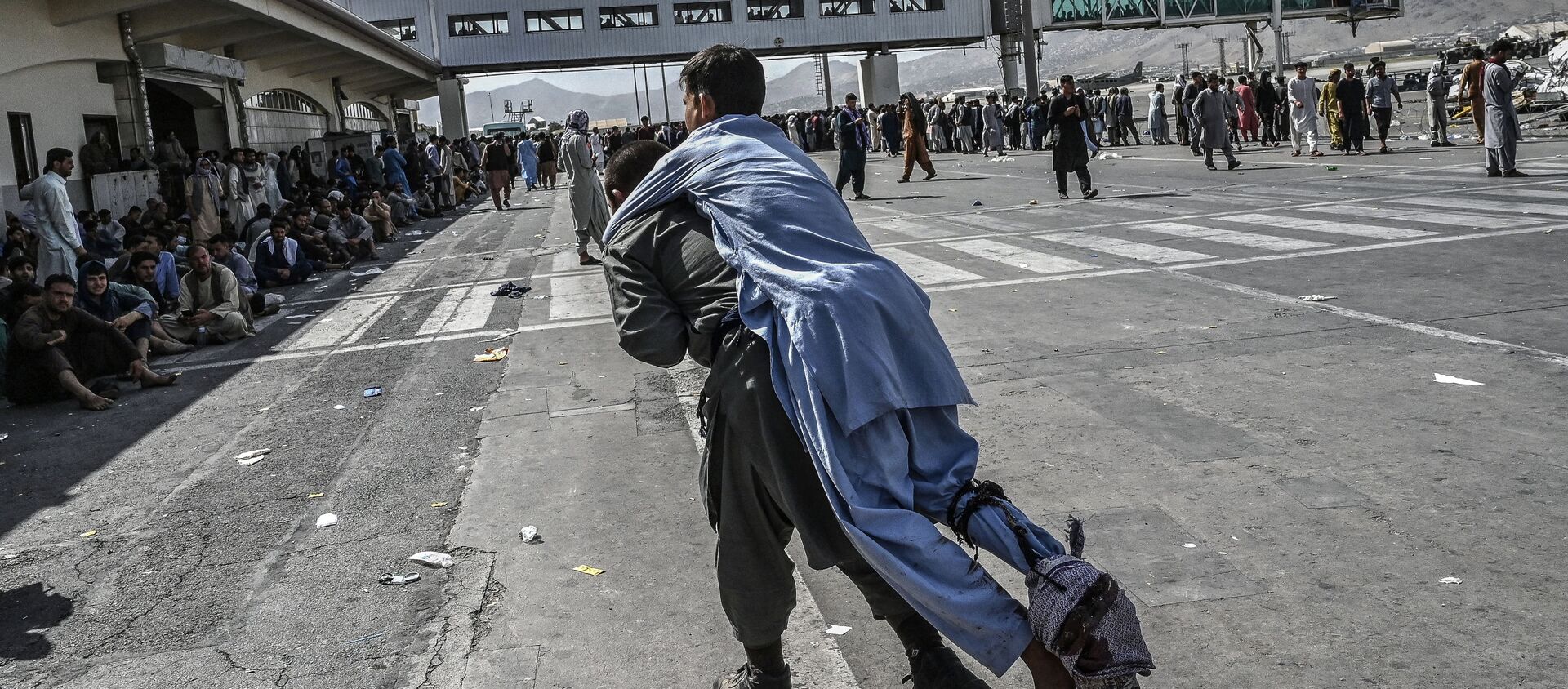 متطوع ينقل جريح أفغاني في مطار كابول - سبوتنيك عربي, 1920, 18.08.2021
