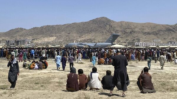 في 16 أغسطس 2021، صورة ملف تجمع مئات الأشخاص بالقرب من طائرة نقل تابعة للقوات الجوية الأمريكية من طراز سي-17، على طول محيط المطار الدولي في كابول، أفغانستان. - سبوتنيك عربي