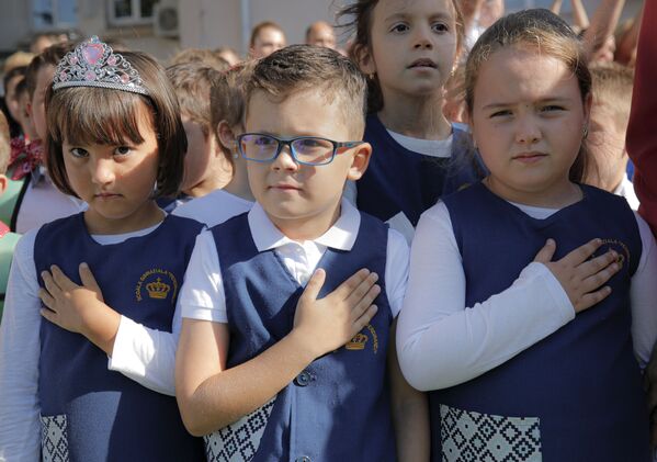 أطفال يضعون أيديهم على صدورهم عند عزف النشيد الوطني، خلال الاحتفالات بمناسبة بداية العام الدراسي في مدرسة فرديناند الأولى في بوخارست، رومانيا، 9 سبتمبر  2019 - سبوتنيك عربي