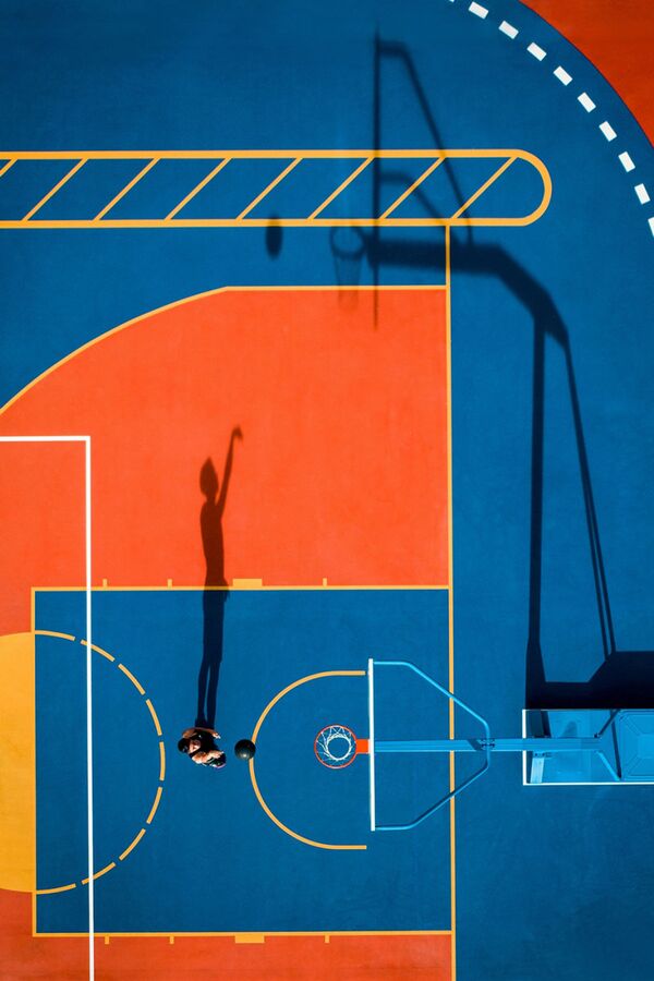 صورة بعنوان رمية واحدة، للمصور لامبسون كارمين يب، الحائز على تقدير عالي في فئة رياضة من مسابقة التصوير بواسطة الدرون لعام 2021

لاعب كرة السلة في هونغ كونغ، هيو هيون هانغ هايمان، يتدرب على التصوير خلال حفل افتتاح ملعب سيو هاي سبورتس في 4 يوليو 2020 - سبوتنيك عربي