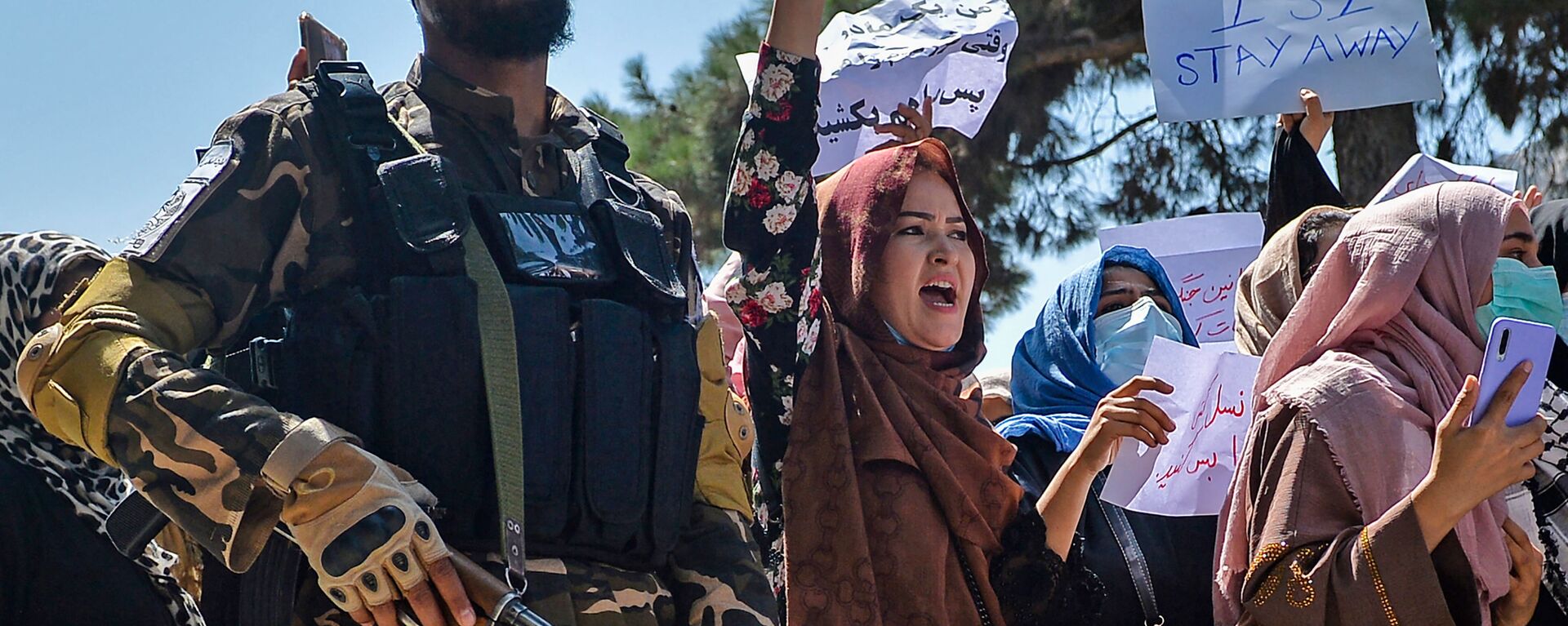 نساء أفغانيات يرددن شعارات بجانب أحد مسلحي حركة طالبان خلال مظاهرة مناهضة لباكستان بالقرب من السفارة الباكستانية في كابول، أفغانستان 7 سبتمبر 2021 - سبوتنيك عربي, 1920, 21.12.2022
